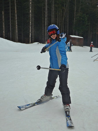 A young woman on alpine ski poses on a mountain slope.の写真素材
