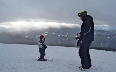 Little boy skiing with his father on the top of a mountain.の写真素材