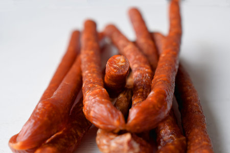 Thin dehydrated pork sausage on a white background.の写真素材