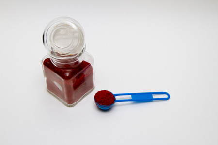 glass jar for spice with red paprika and spoonの写真素材