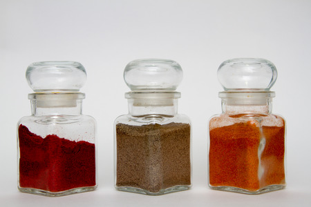 glass spice jars with different kinds of pepperの写真素材