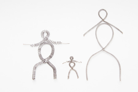 figures of men of wire laid out on a white backgroundの写真素材