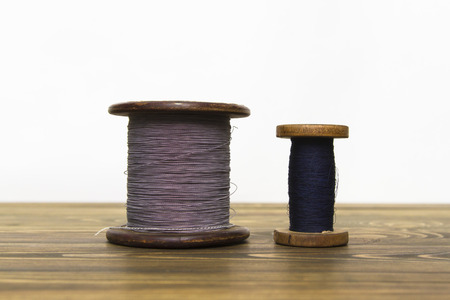 wire spool standing on the table of the old boardsの写真素材