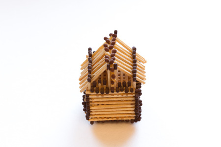 toy house made of matches on a white backgroundの写真素材