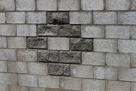 The wall of gray brick with a pattern in the form of a rhombus