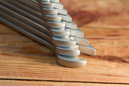set of wrenches stacked on a wooden bench
