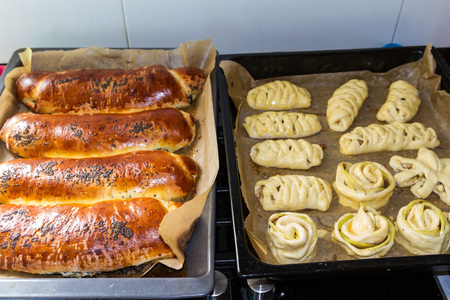 Homemade cakes ready and raw on baking traysの写真素材