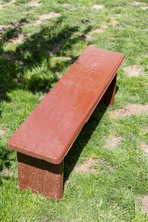 Lonely brown bench standing on the lawn