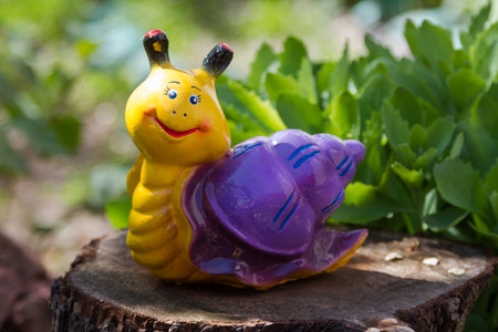 garden figurine on a purple snail stumpの写真素材