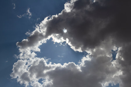 beautiful rain cloud with sun rays on blue skyの写真素材