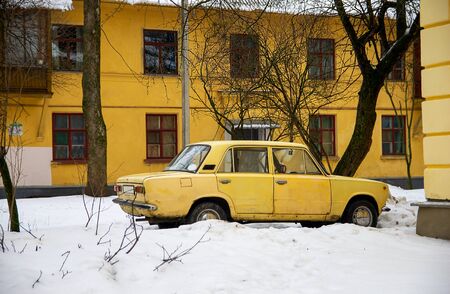 Old yellow car on snow backgroundの写真素材