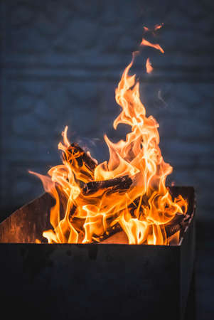 Orange fire burns at night in grillの写真素材