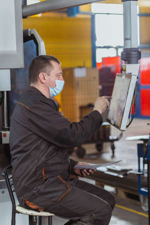 Bila Tserkva, Ukraine, March 2021: The operator tune a cnc machine at the factoryのeditorial素材