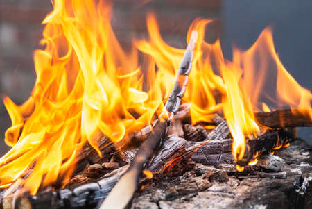 close-up of Orange flame and charred burning firewood