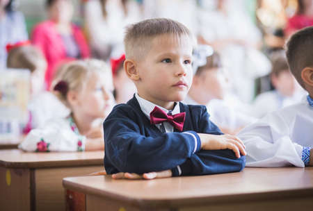 Bila Tserkva, Ukraine, August, 2016: Cute schoolboy with bow tie sits at school deskのeditorial素材