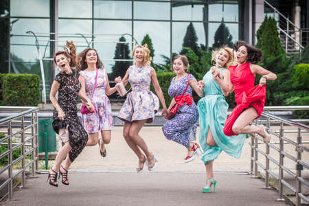 Kiev, Ukraine, July, 2015: Beautiful girls university graduates jumping with happiness under rainのeditorial素材