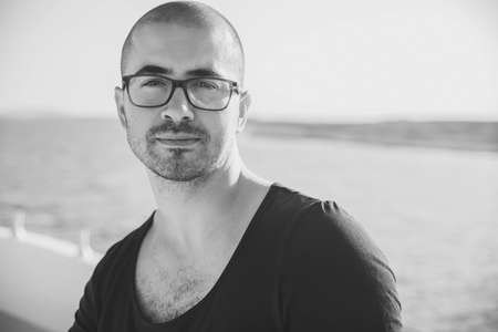attractive guy with glasses resting on a yachtの写真素材