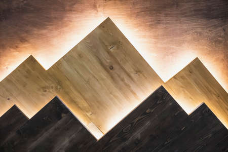 Wood wall with hidden backlight similar to mountains. Interior element