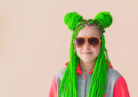Teenage girl with green pigtails from which the horns are twisted