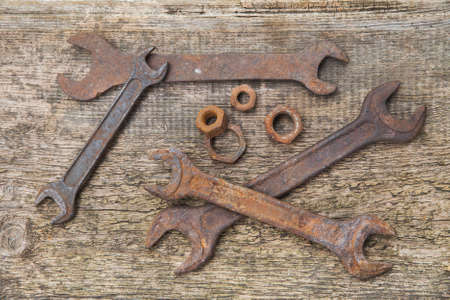 rusty wrenches and nuts on old unpainted boards