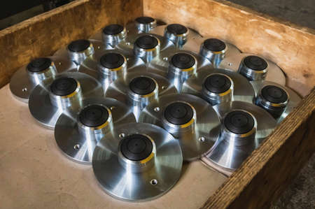 round polished metal workpieces lie in a wooden box at factory in stockの写真素材