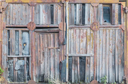 old rotten wooden gate with a metal frameの写真素材