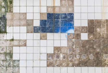 dirty white tile with chipped edges on the wallの写真素材