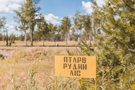 Chernobyl, Ukraine, August 2020: "Red Forest" warning sign. The forest changed its color due to absorption of radiation after the Chernobyl accidentのeditorial素材