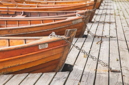 Bled, Slovenia, October 2020: Boats with manufacturer's signs are moored by a chain on Lake Blaysko...
