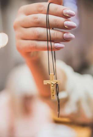 woman hold wooden cross with golden crucifix in handの写真素材