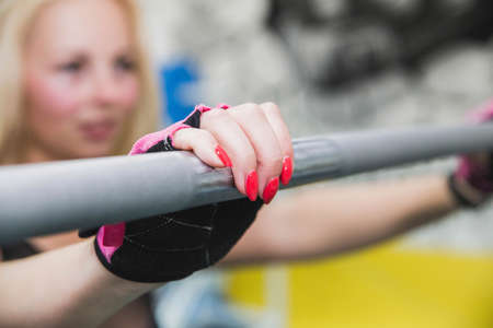 Hands with red nail polish on the barbellの写真素材