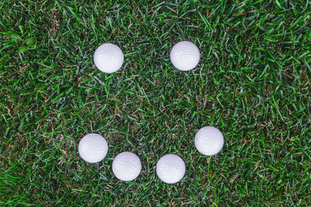 Golf balls lie in the shape of a smile on the lawnの写真素材
