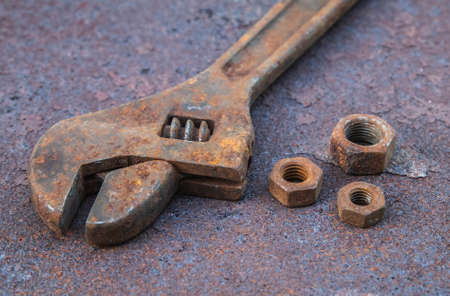 Old wrench and nuts on a rusty countertopの写真素材