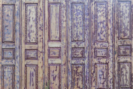 fence made of old doors with peeling paintの写真素材