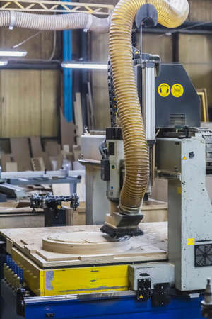 CNC machine cuts a round piece at the factoryのeditorial素材