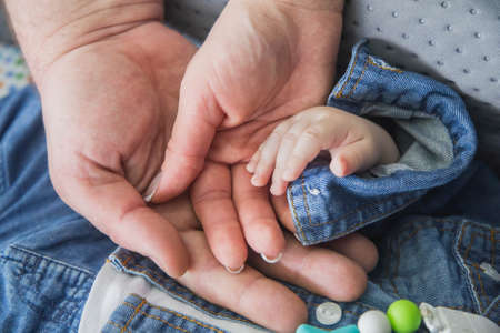 married couple holding the hand of their newborn babyの写真素材