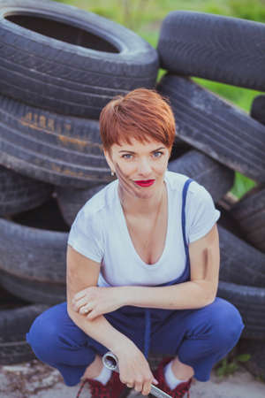 attractive woman mechanic in overalls holding wrenchの写真素材
