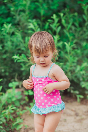 Lovely baby in swimsuit on the beachの写真素材