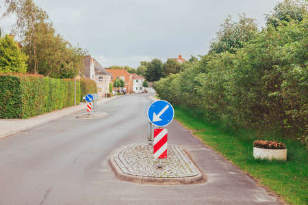 Concrete islands on a street in Denmark that force drivers to slow down. Focus in the foreground