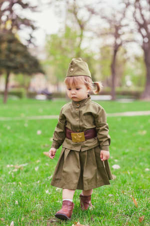 Sad baby girl in Soviet military uniformの写真素材
