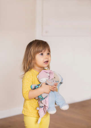 Charming baby hugging soft toys. Place for textの写真素材