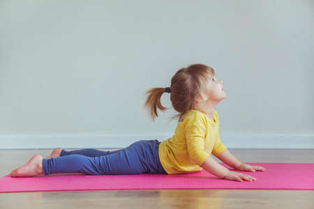 Charming baby doing yoga. Place for text