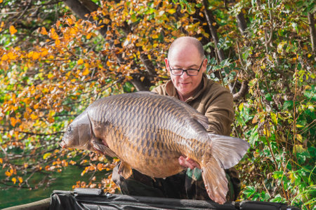 Bled, Slovenia, October 2020: A fisherman holds a huge carp near Lake Bledのeditorial素材