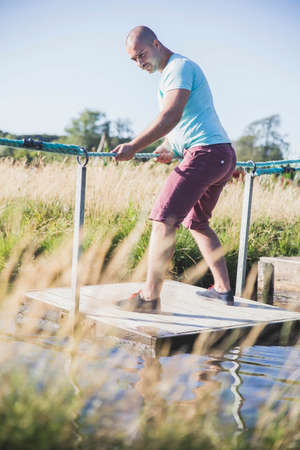 Short hair guy crosses the canal on a raftの写真素材