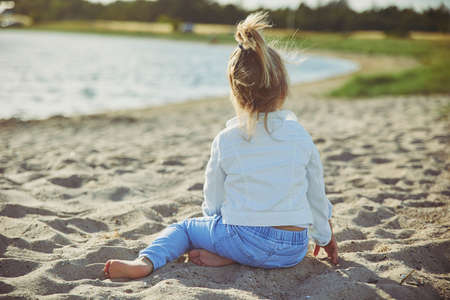 Charming child walking on the beach at sunset