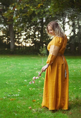 beautiful Ukrainian woman in embroidered dress holds a sprig of cottonの写真素材