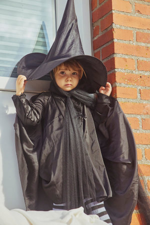 Adorable child on porch dressed in halloween costumeの写真素材