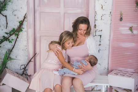 happy mom hugs daughters in the living room