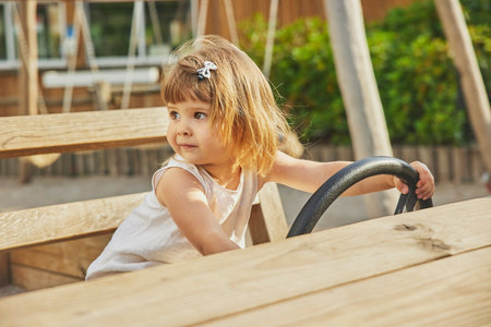 Adorable little girl playing in a wooden carの写真素材