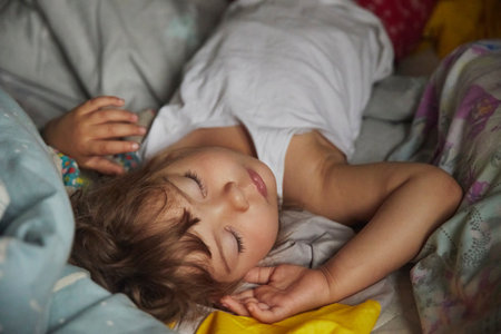 adorable baby sleeping in a dark roomの写真素材